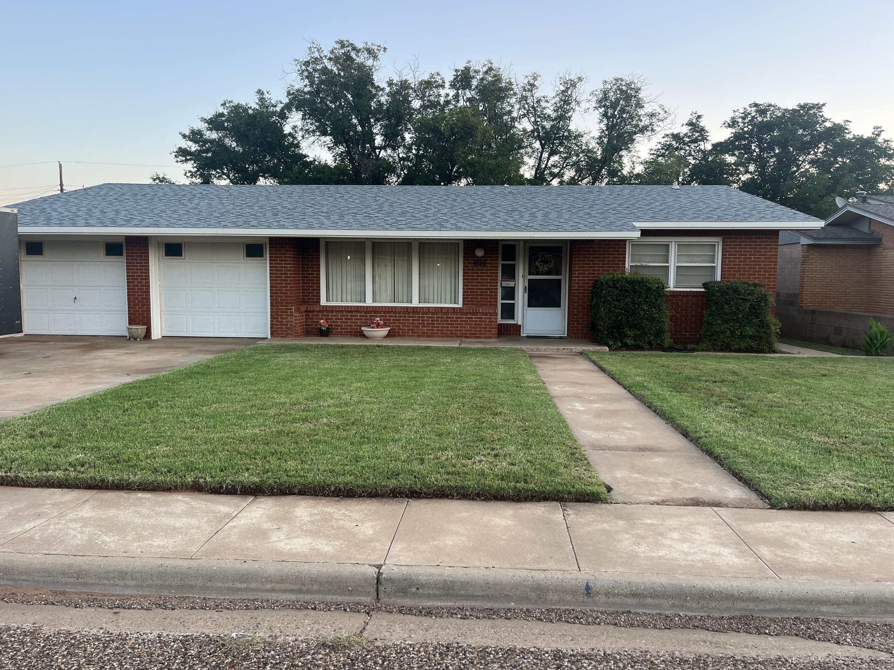404 North 21st Street Lamesa, TX 79331 - Photo 2 of 30 a front view of a house with a yard and garage