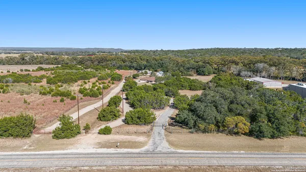 an aerial view of residential houses with outdoor space and trees