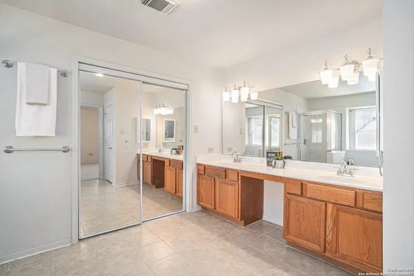 a large bathroom with a double vanity sink a mirror and a shower