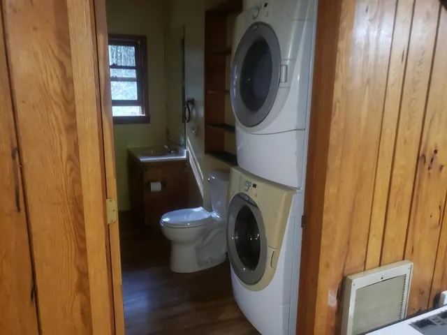 an empty room with wooden floor closet and windows