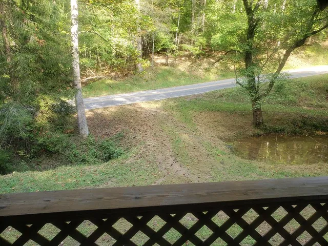 a view of a backyard with wooden fence and a bench