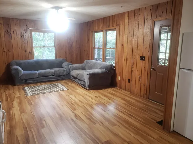 a kitchen with wooden floors and white stainless steel appliances