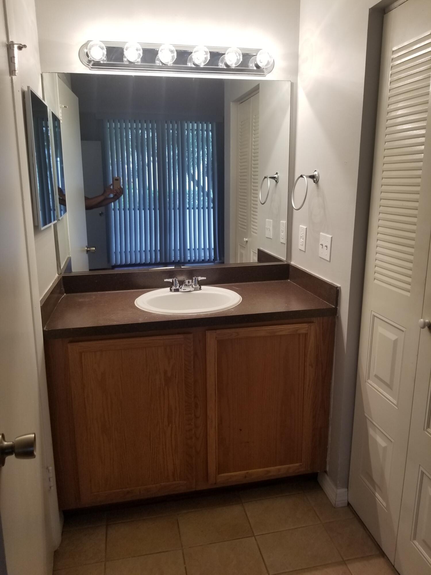 718 Executive Center Drive, Unit 19 West Palm Beach, FL 33401 - Photo 9 of 20 a bathroom with a sink and a mirror