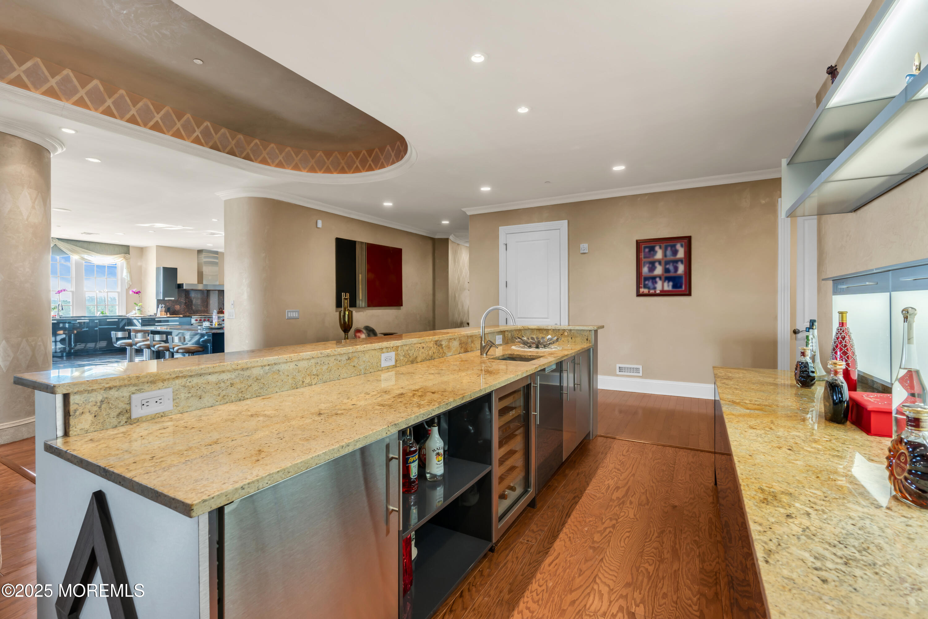 1041 Oval Road Manasquan, NJ 08736 - Photo 7 of 30 a large kitchen with kitchen island a stove a sink dishwasher and a dining table with wooden floor