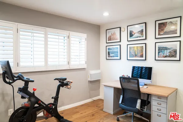 a view of a workspace with furniture and a window