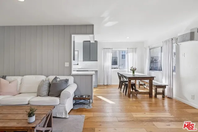 a living room with furniture and a dining table with wooden floor