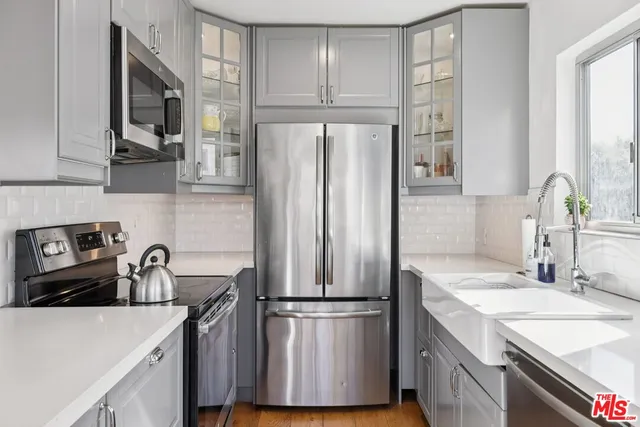 a kitchen with a refrigerator sink and cabinets