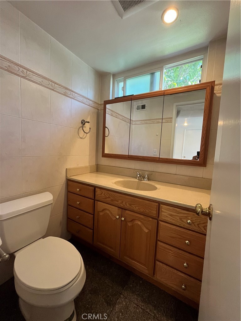 17401 Appalachian Street Fountain Valley, CA 92708 - Photo 8 of 23 a bathroom with a toilet sink and mirror