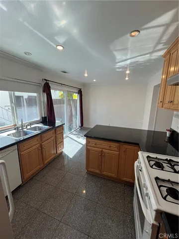 a kitchen with granite countertop a sink and a stove top oven