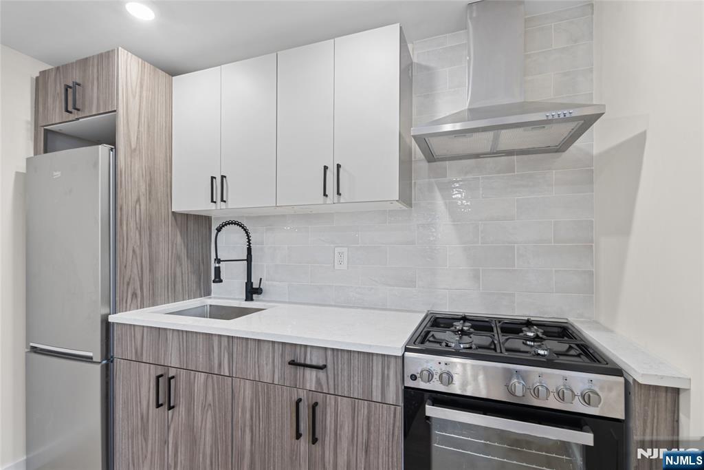 369 Hops Lane Secaucus, NJ 07094 - Photo 10 of 17 a kitchen with a sink stove and cabinets