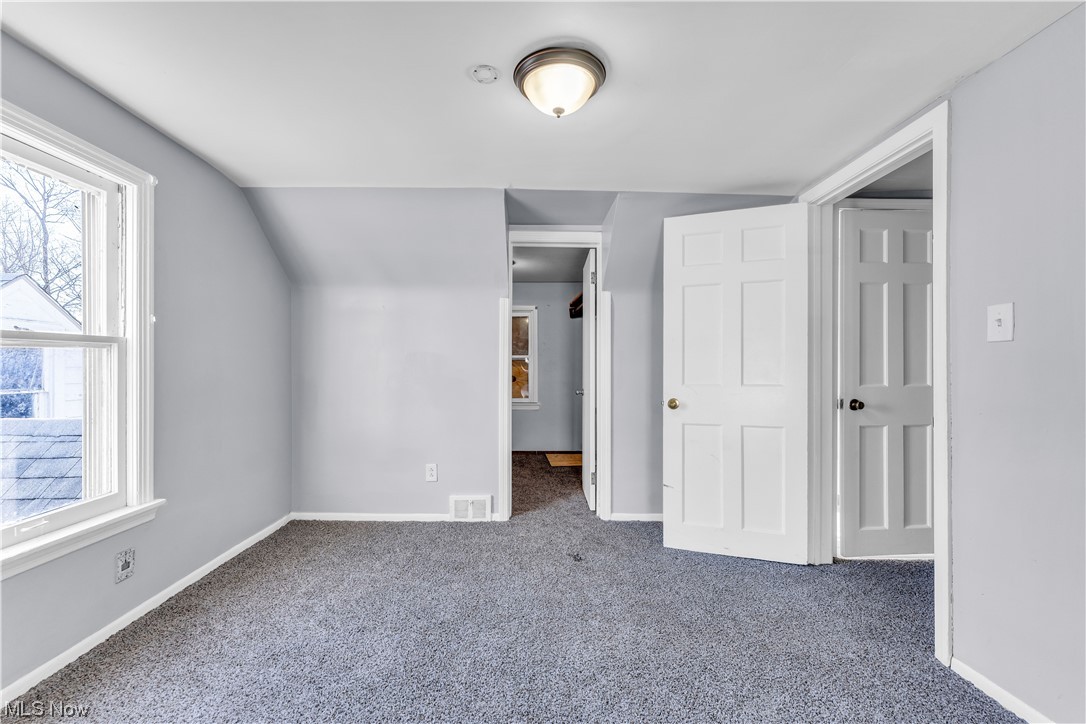 15400 Rockside Road Maple Heights, OH 44137 - Photo 20 of 31 Unfurnished bedroom featuring multiple windows, a closet, dark carpet, and vaulted ceiling