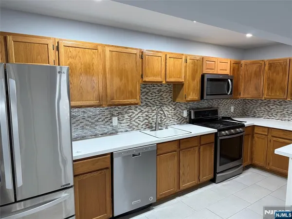 a kitchen with stainless steel appliances granite countertop a refrigerator stove and sink