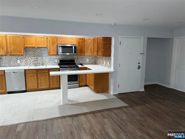 a kitchen with stainless steel appliances granite countertop a stove top oven and sink