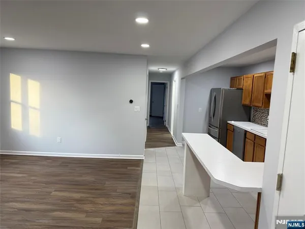 a view of a kitchen with fridge and wooden floor