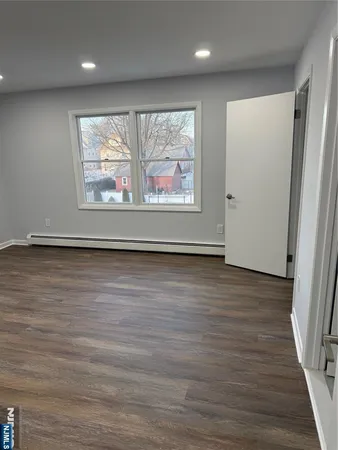 an empty room with wooden floor and window