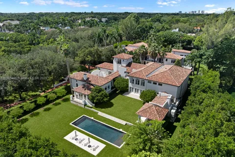 an aerial view of a house with pool garden and mountain view in back