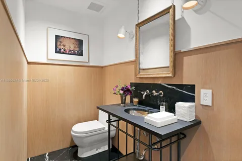 a bathroom with a toilet a sink and mirror