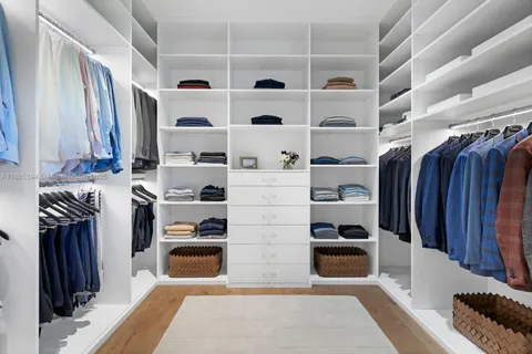 a view of walk in closet with clothes and shoes
