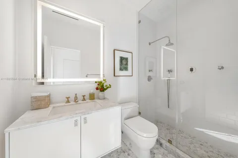 a bathroom with a granite countertop toilet sink and shower