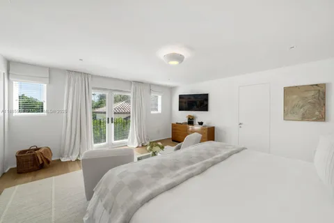 a bedroom with a bed window and television