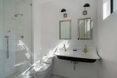 a bathroom with a sink and mirror with toilet
