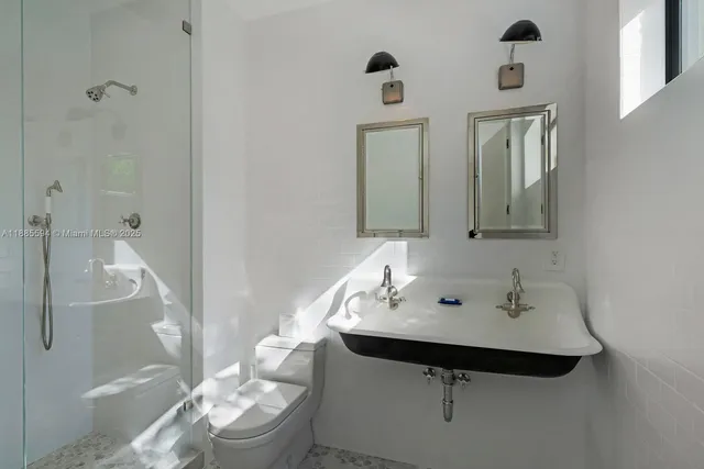 a bathroom with a sink and mirror with toilet