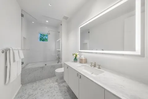 a bathroom with a double vanity sink toilet and shower