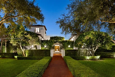 a front view of a house with a yard and potted plants