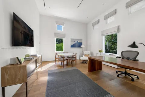 a living room with furniture a flat screen tv and a window