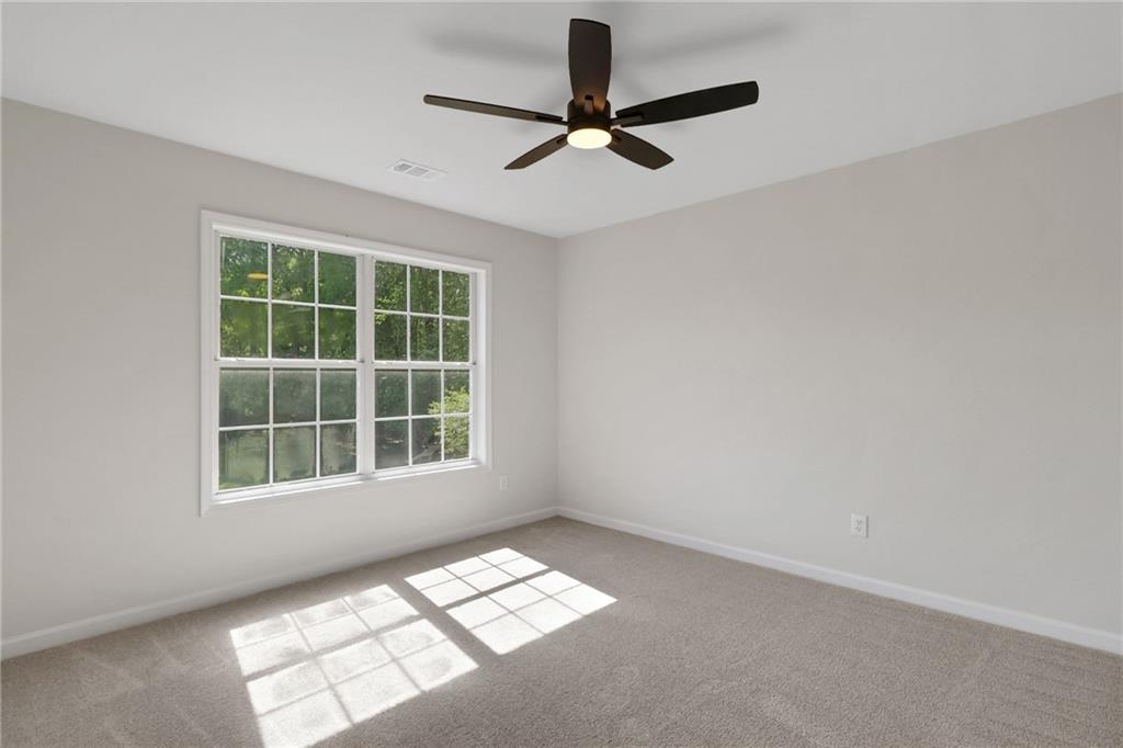 6259 Spring Lake Drive Flowery Branch, GA 30542 - Photo 15 of 35 a view of wooden floor and a chandelier fan in a room