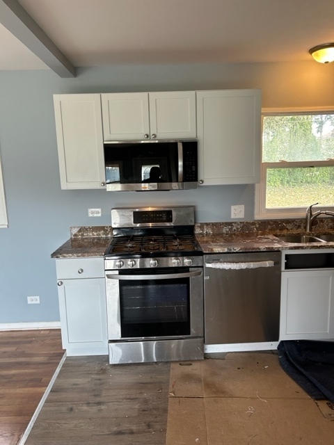 200 Flagstaff Lane Hoffman Estates, IL 60169 - Photo 3 of 19 a kitchen with stainless steel appliances granite countertop a stove a sink and a microwave
