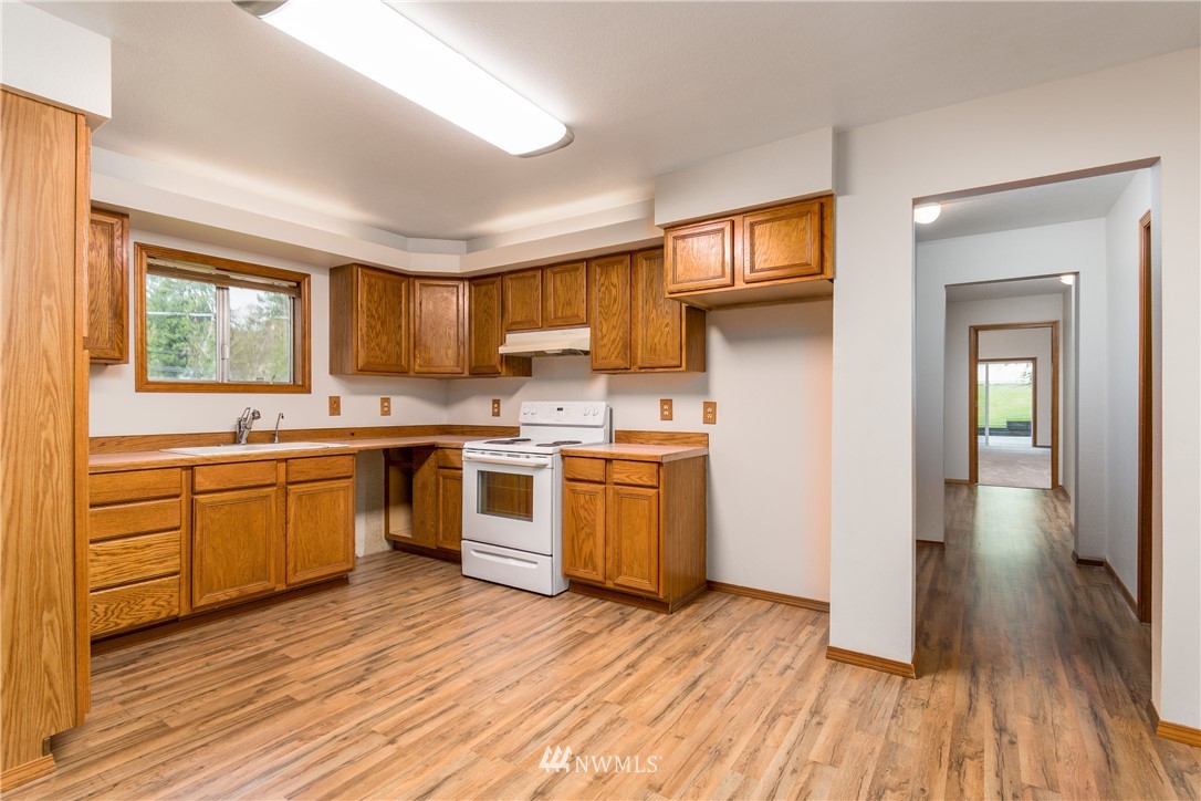 1320 Coal Creek Road Longview, WA 98632 - Photo 10 of 34 a kitchen with a sink wooden floor and stainless steel appliances