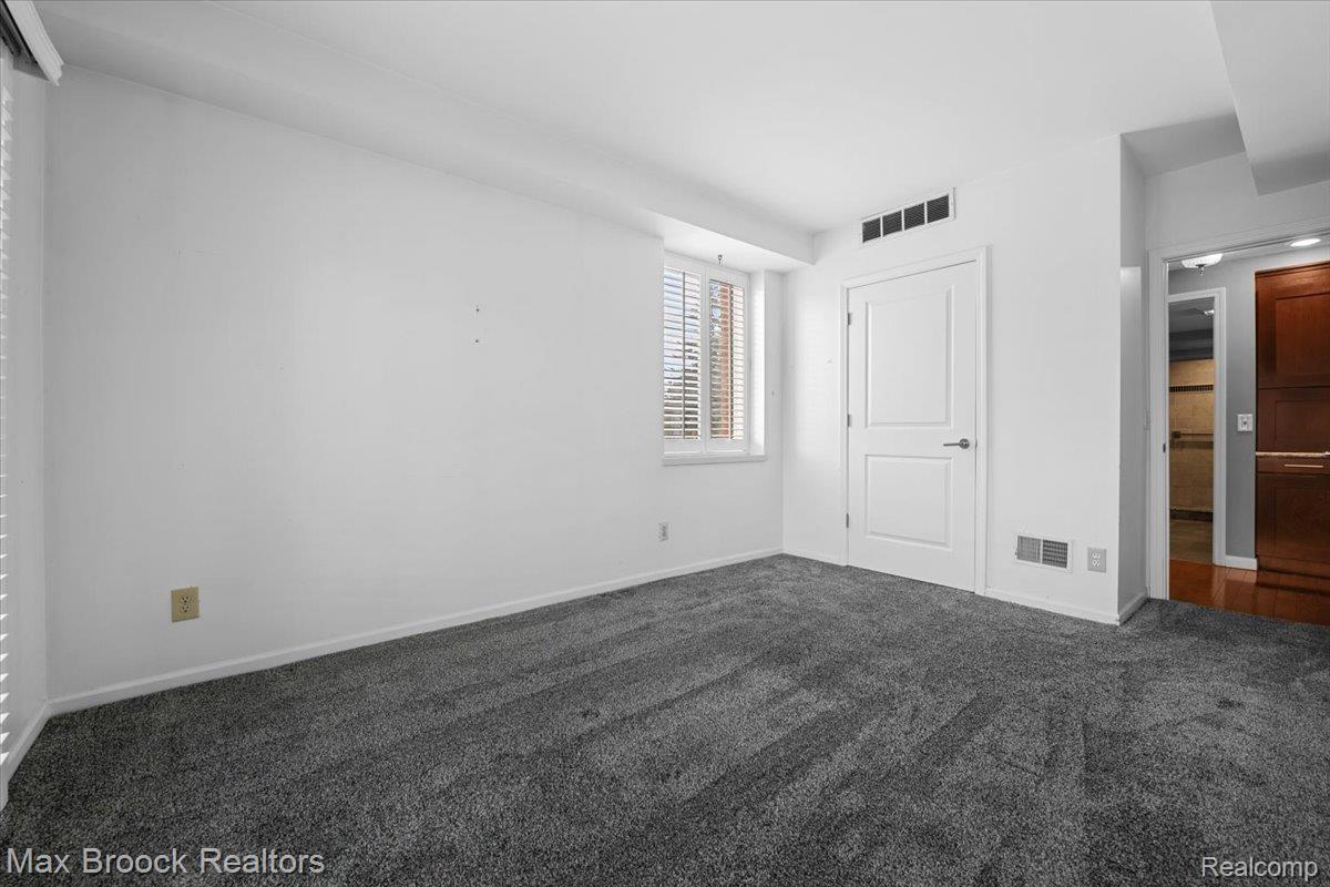 969 GreenView Court, Unit 42 Rochester, MI 48307 - Photo 27 of 41 Unfurnished bedroom featuring dark carpet and baseboards