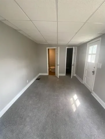 an empty room with a mirror and a ceiling fan