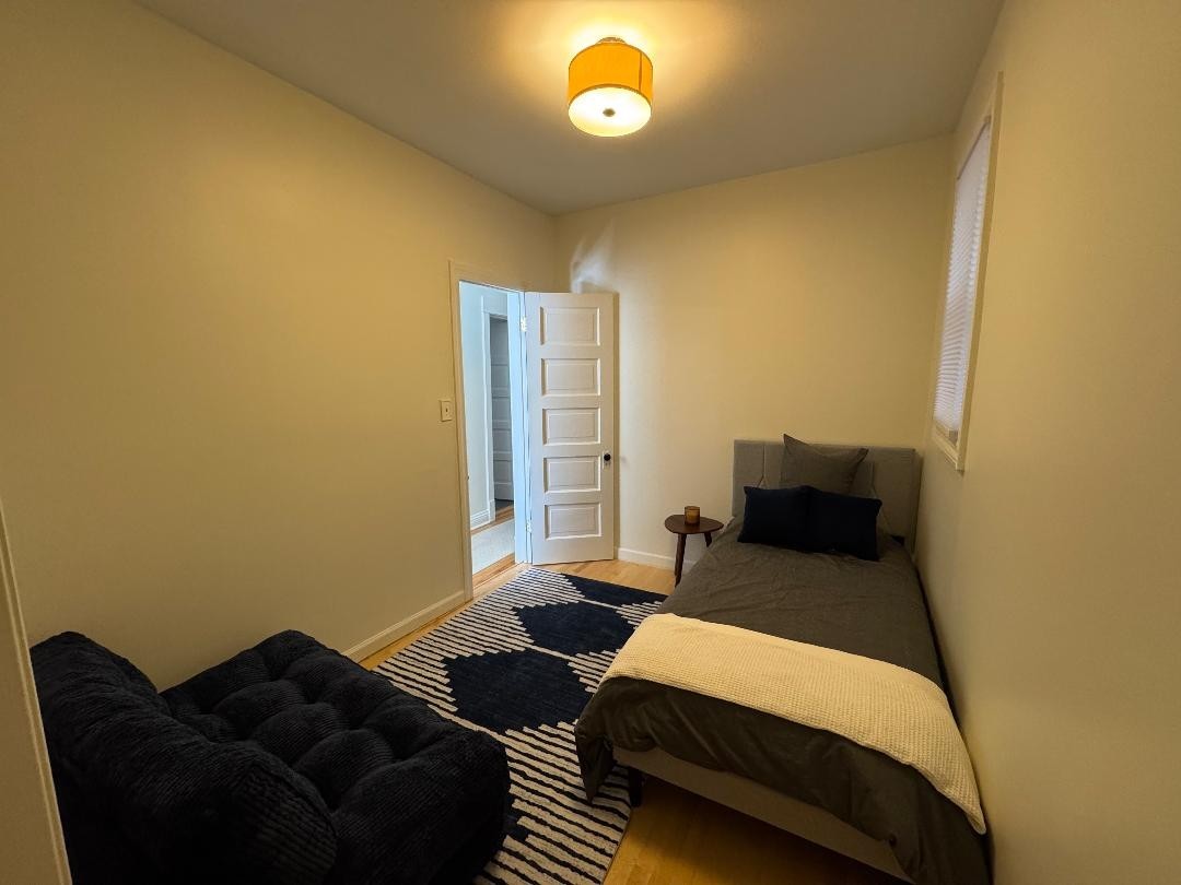 1831 West Nelson Street, Unit 1 Chicago, IL 60657 - Photo 4 of 11 a bedroom with a bed and a lamp next to a window