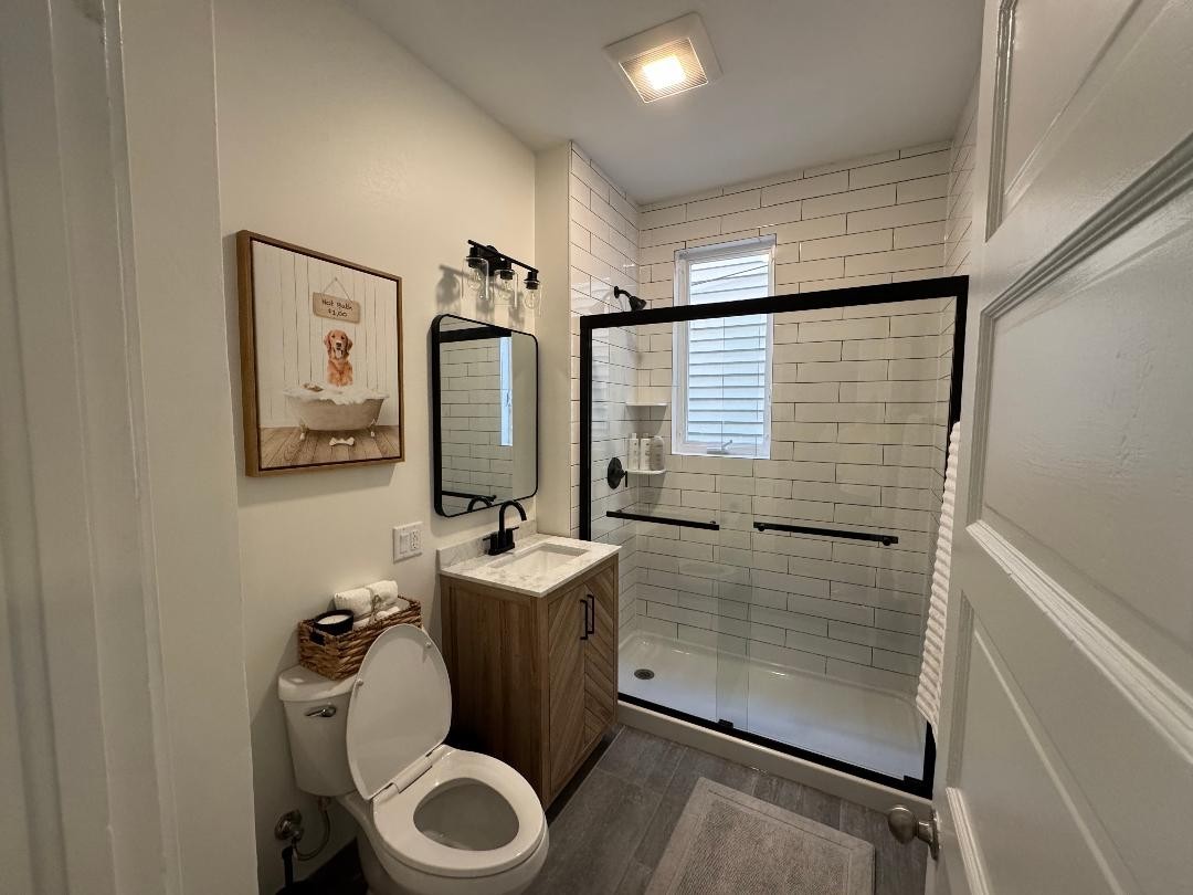 1831 West Nelson Street, Unit 1 Chicago, IL 60657 - Photo 6 of 11 a bathroom with a toilet a sink and mirror