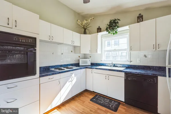 a kitchen with granite countertop a sink stainless steel appliances and cabinets