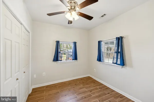 a view of an empty room with a window and a ceiling fan