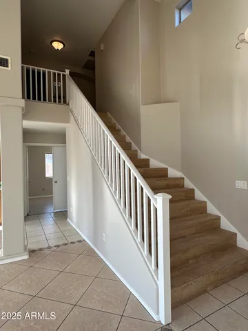 a view of staircase with lots of frames on wall and a potted plant