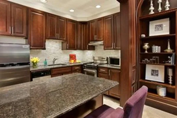 a kitchen with a refrigerator and a stove top oven