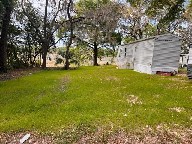 a view of yard with swimming pool and trees