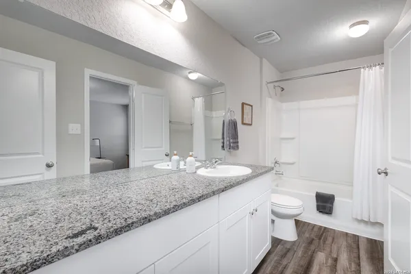 a bathroom with a granite countertop sink and a mirror