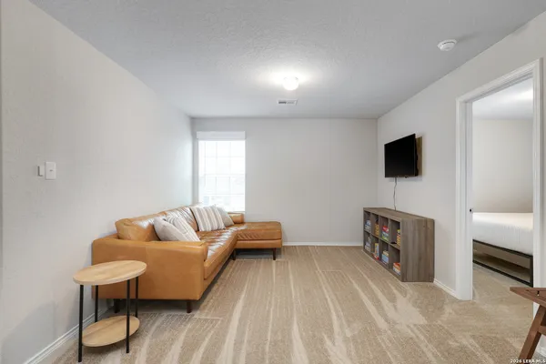 a bedroom with furniture and a flat screen tv