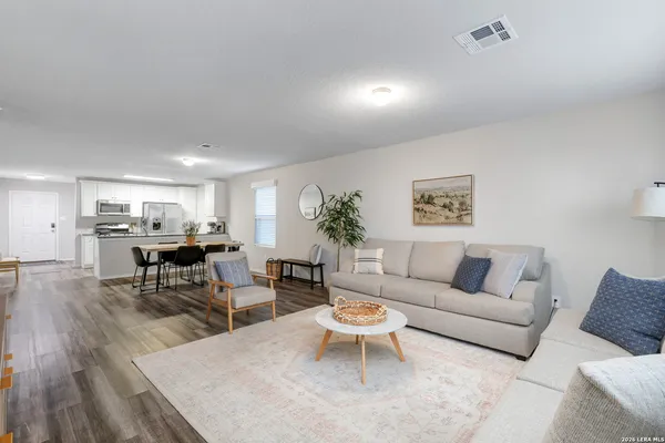 a living room with furniture and view of kitchen