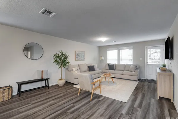 a living room with furniture dining table a lamp and a flat screen tv
