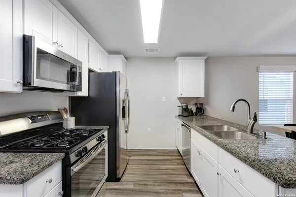 a kitchen with stainless steel appliances granite countertop a sink stove and refrigerator