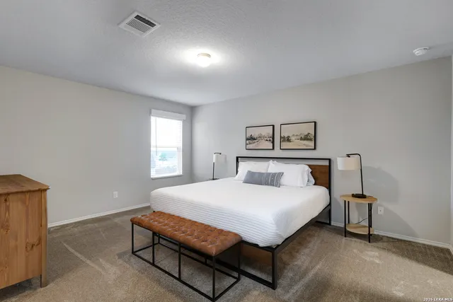 a bedroom with a bed lamp and a window