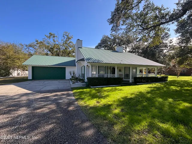 a front view of a house with a yard garden and outdoor seating