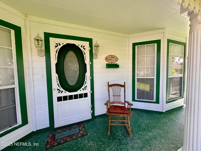 a dining room with furniture a kitchen wooden floor and a ceiling fan