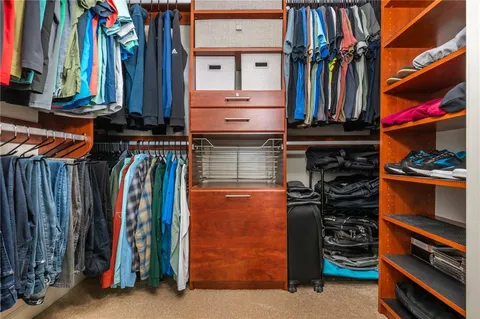 a view of walk in closet with clothes and shoes